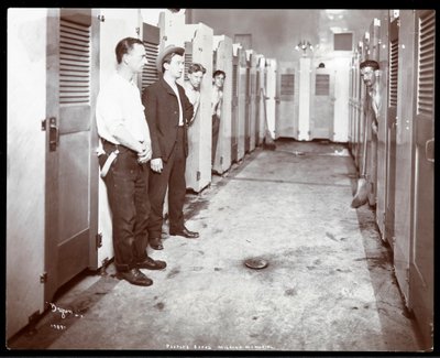 Interior view of young men peering out of bathing stalls at the People